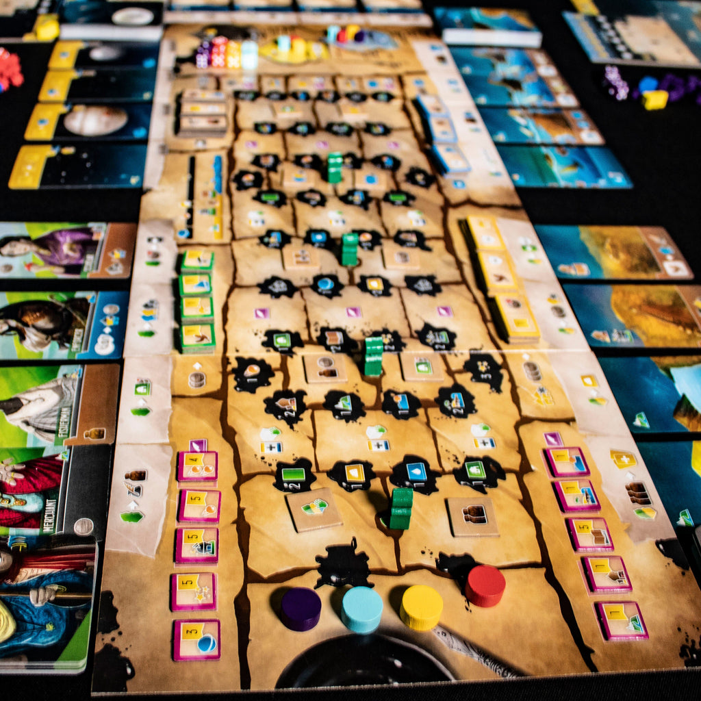 Board game with various cards and pieces on a dark surface