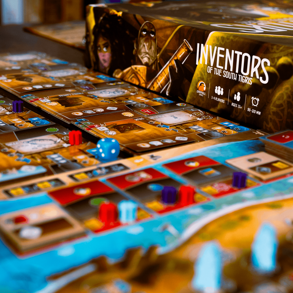 Board game with cards and dice on a table, featuring 'Inventors of the Southlands' box.
